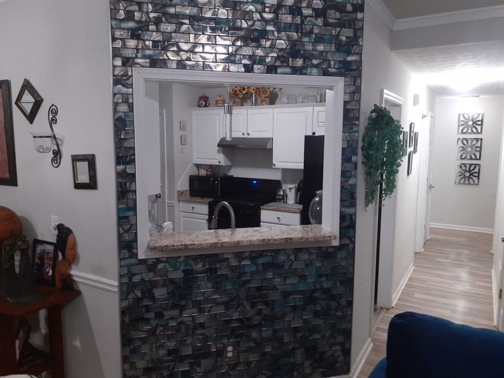 Modern kitchen view through a stylish stone backsplash with granite countertop accents.