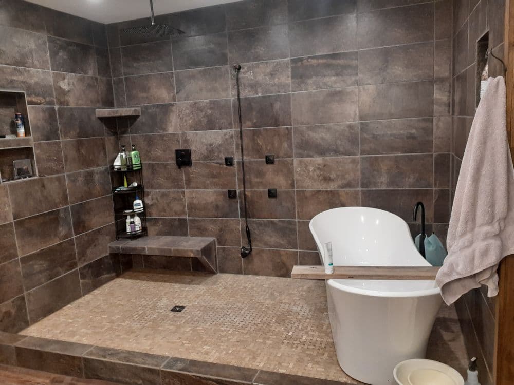 Modern bathroom featuring a freestanding tub, spacious shower, and stone tile accents.