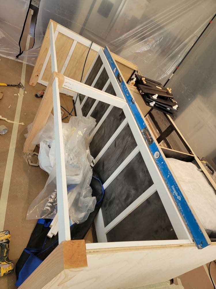 Construction of a custom cabinet with tools and materials visible in a workshop setting.