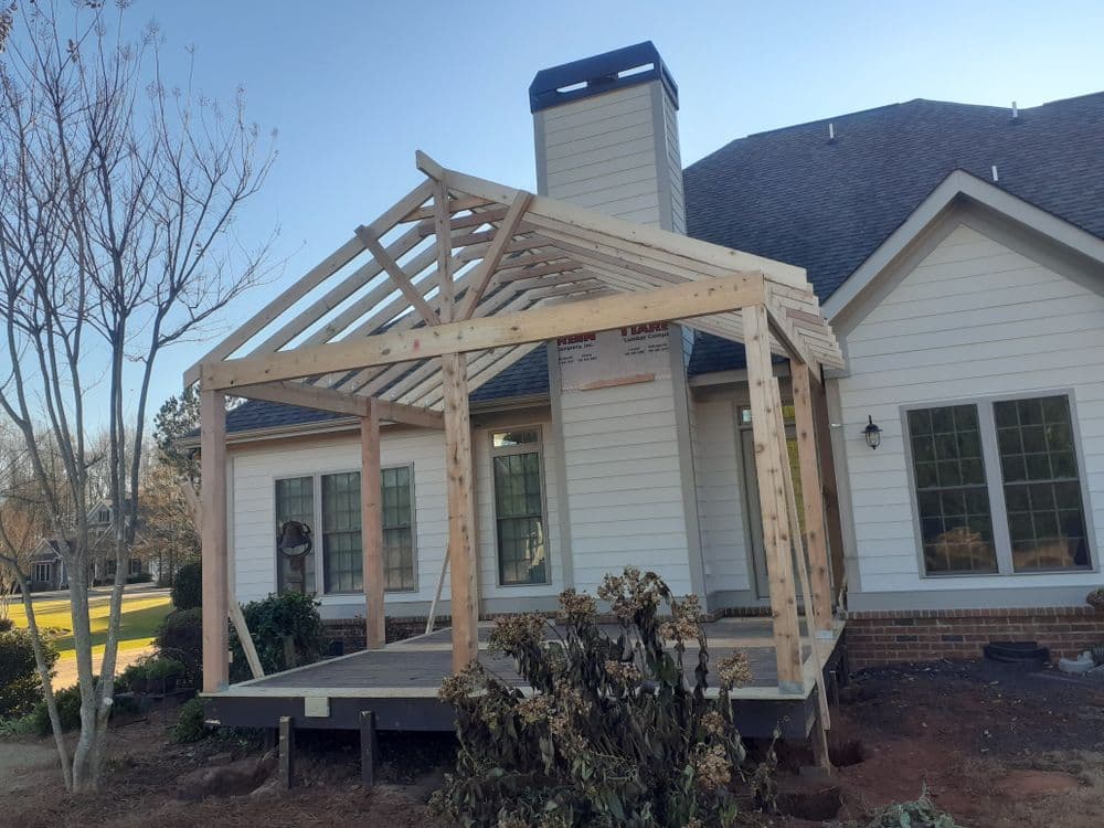Newly constructed wooden framing for a porch addition on a residential home.