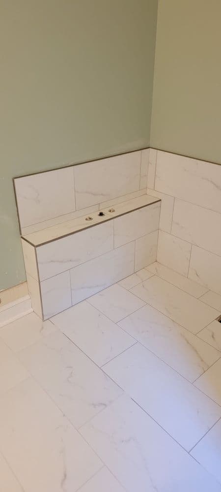 Modern bathroom design featuring white marble tiles and a sleek built-in sink area.
