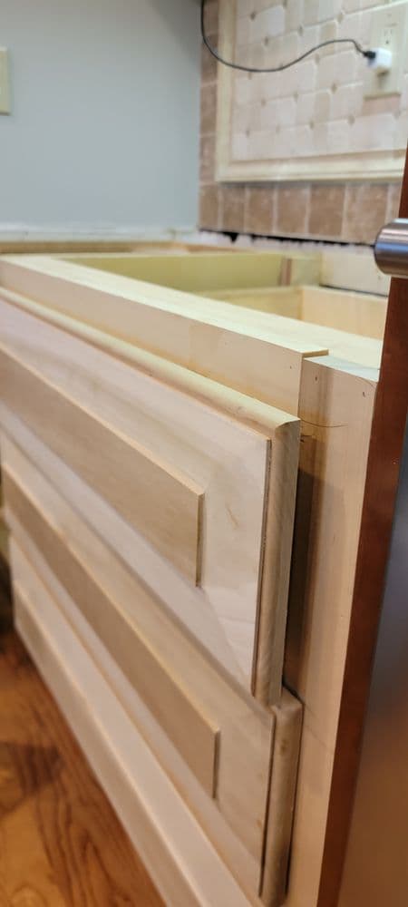 Close-up of unfinished wooden kitchen cabinet drawers in the remodeling process.