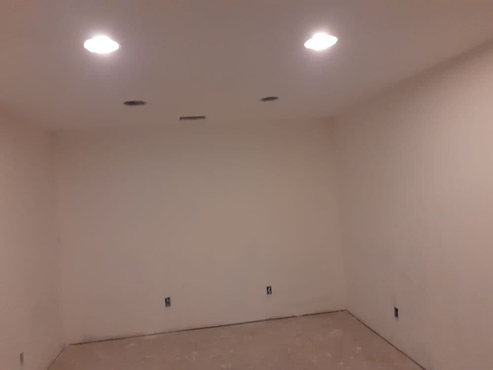 Empty room with recessed lighting and unfinished walls, ready for renovation.