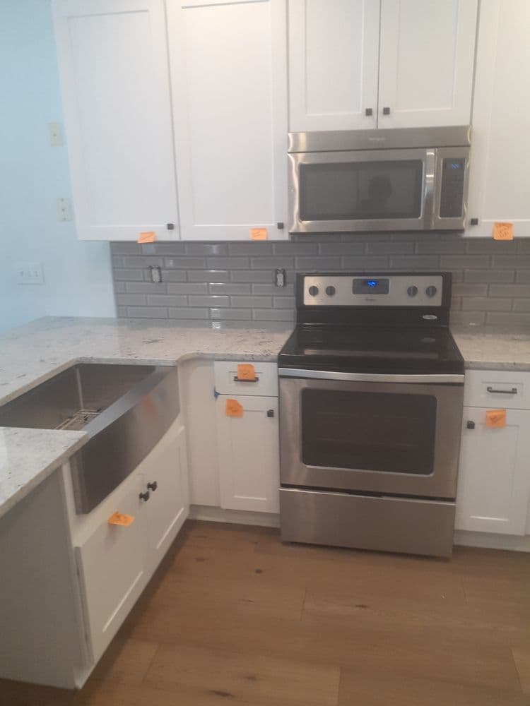 Modern kitchen with stainless steel appliances, granite countertops, and white cabinetry.