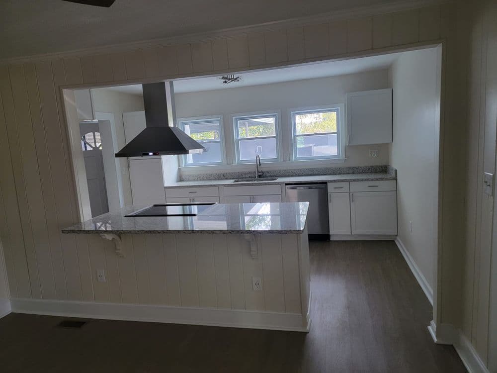 Modern kitchen with granite countertops, stainless steel appliances, and bright natural light.