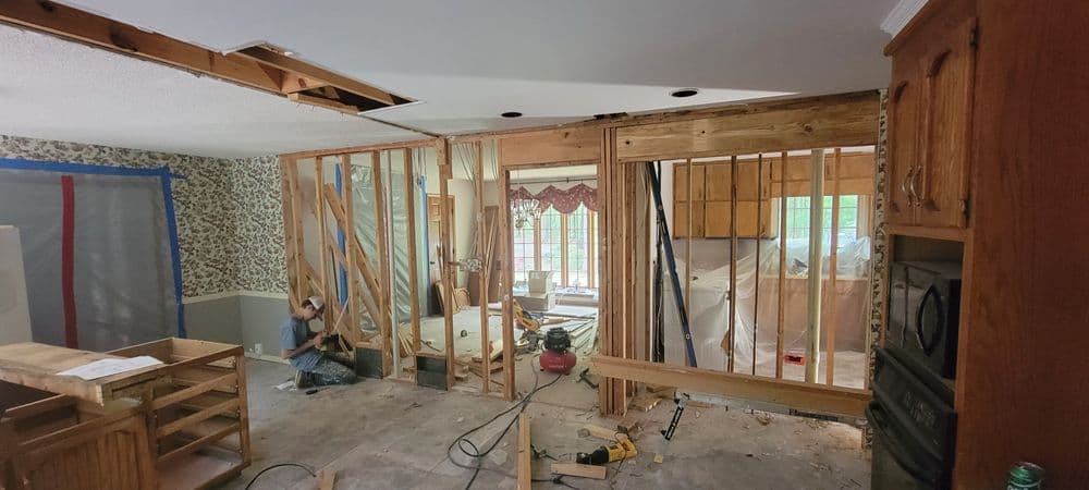 Home renovation in progress, showing exposed framing and construction tools in a kitchen.