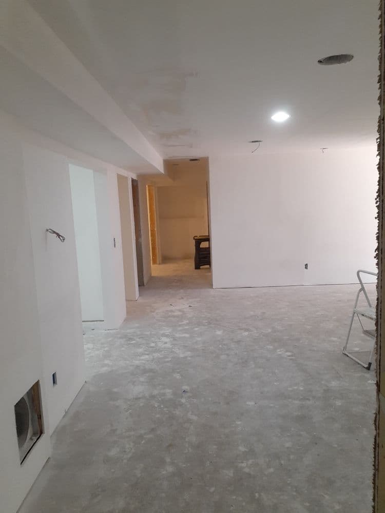 Renovated empty basement with unfinished walls and flooring, showcasing an open layout.