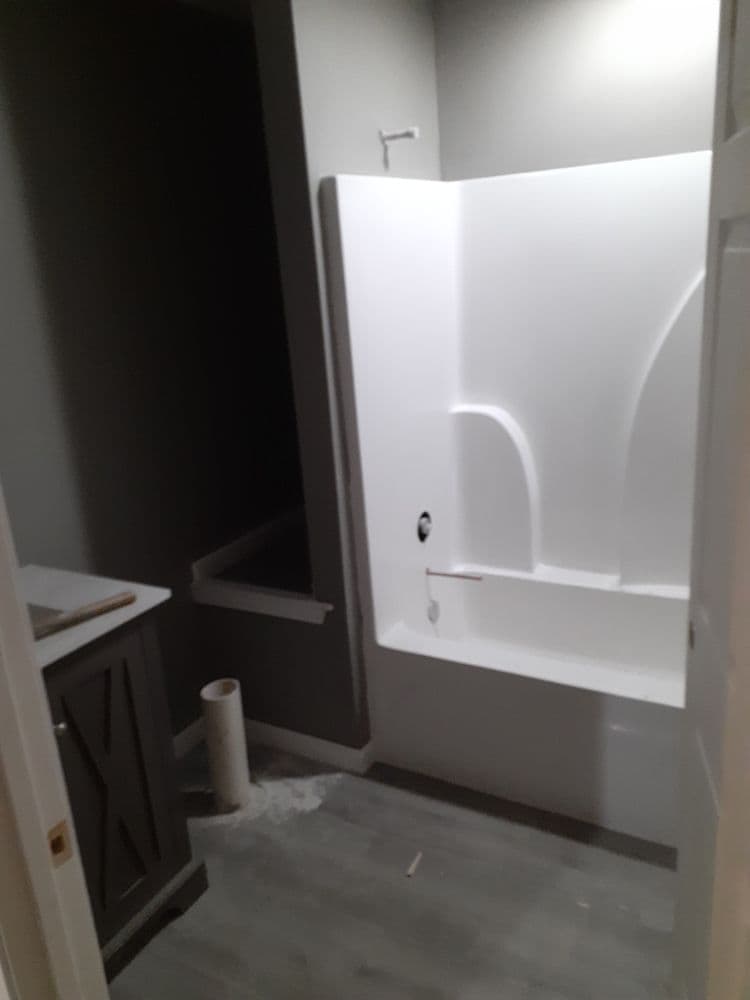 Modern bathroom renovation featuring a white shower and gray walls with a vanity.