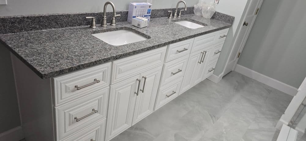 Modern double sink vanity with gray granite countertop and white cabinetry in a stylish bathroom.